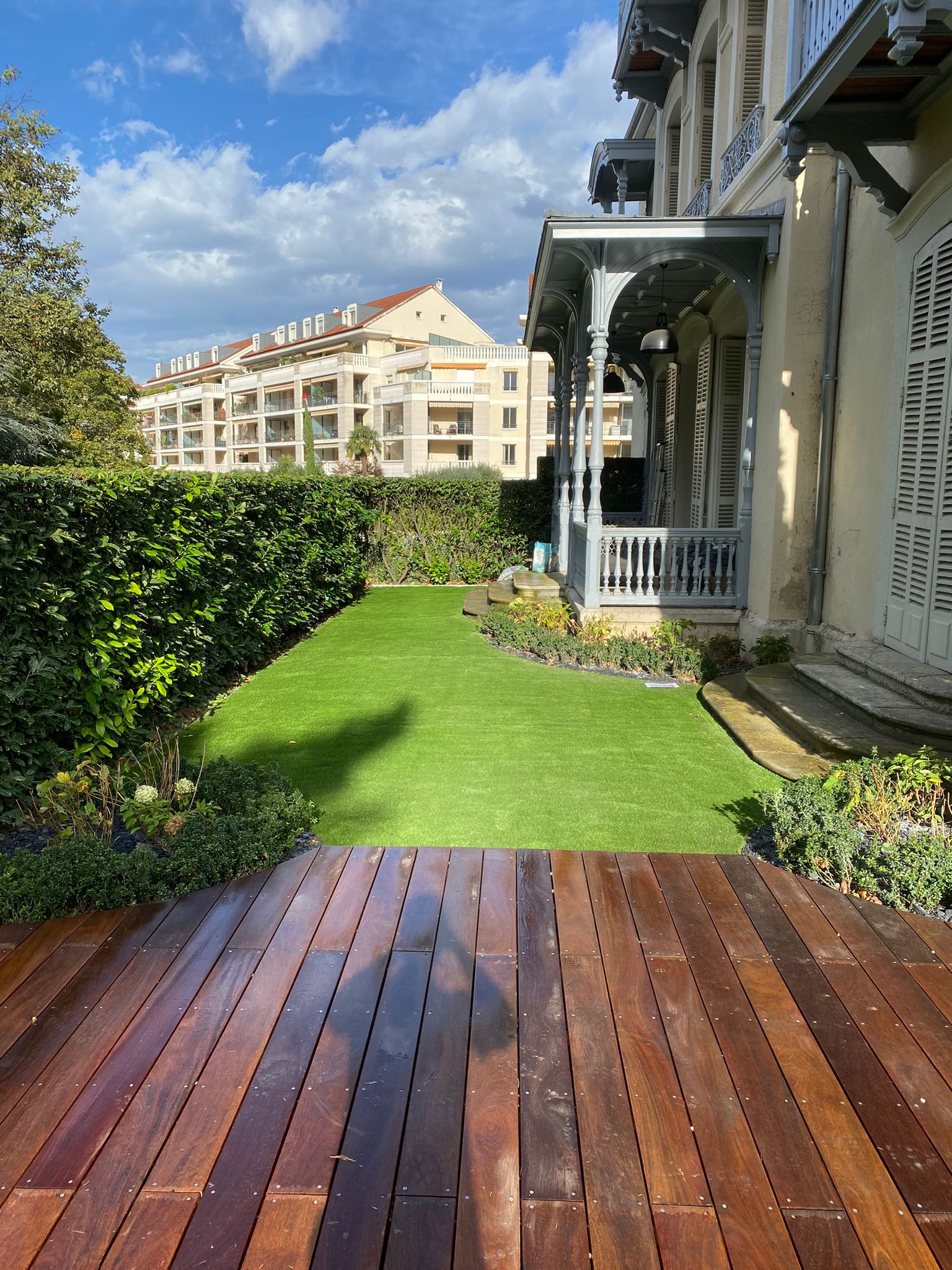 Entrée de jardin avec terrasse bois et bow window